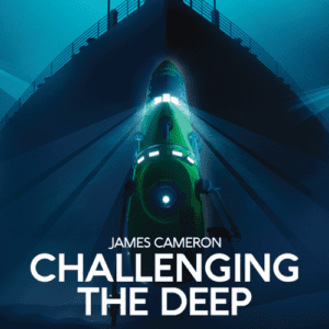A deep-sea submersible is illuminated underwater near a large ship's hull, with the text "James Cameron CHALLENGING THE DEEP" displayed below at the Oregon Museum of Science and Industry (OMSI).