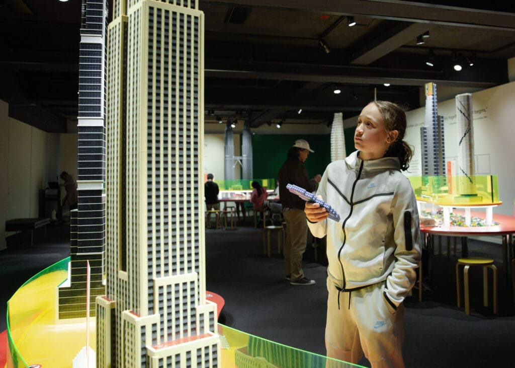 Person examining architectural models indoors.