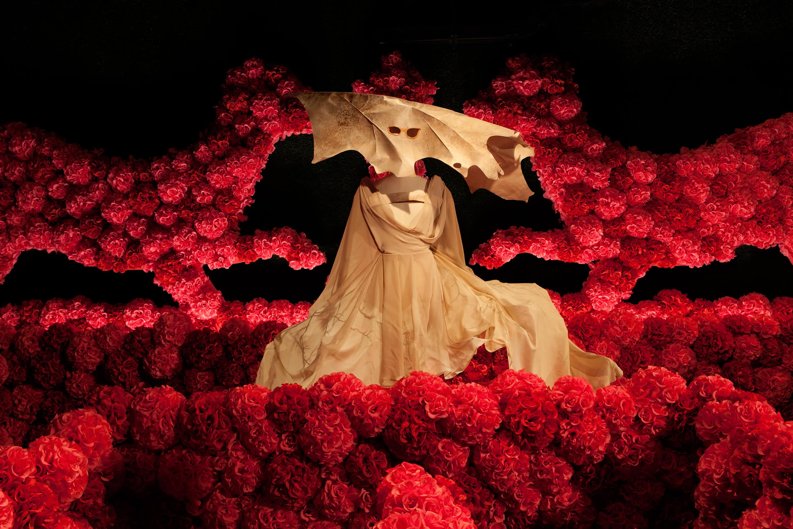 a dress with a mask on it surrounded by red roses