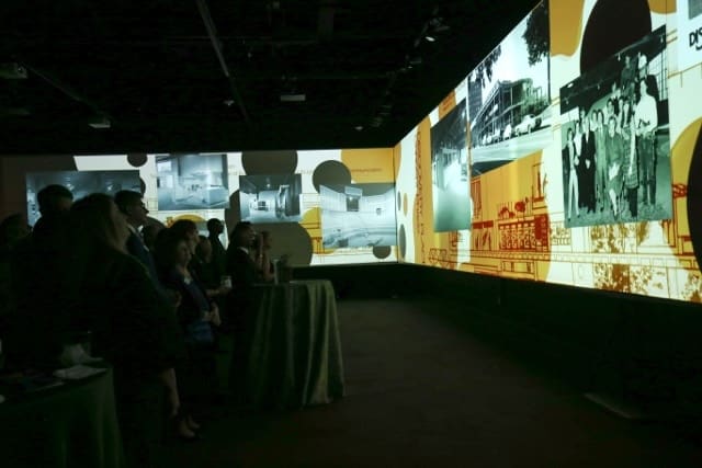 a group of people looking at a large screen