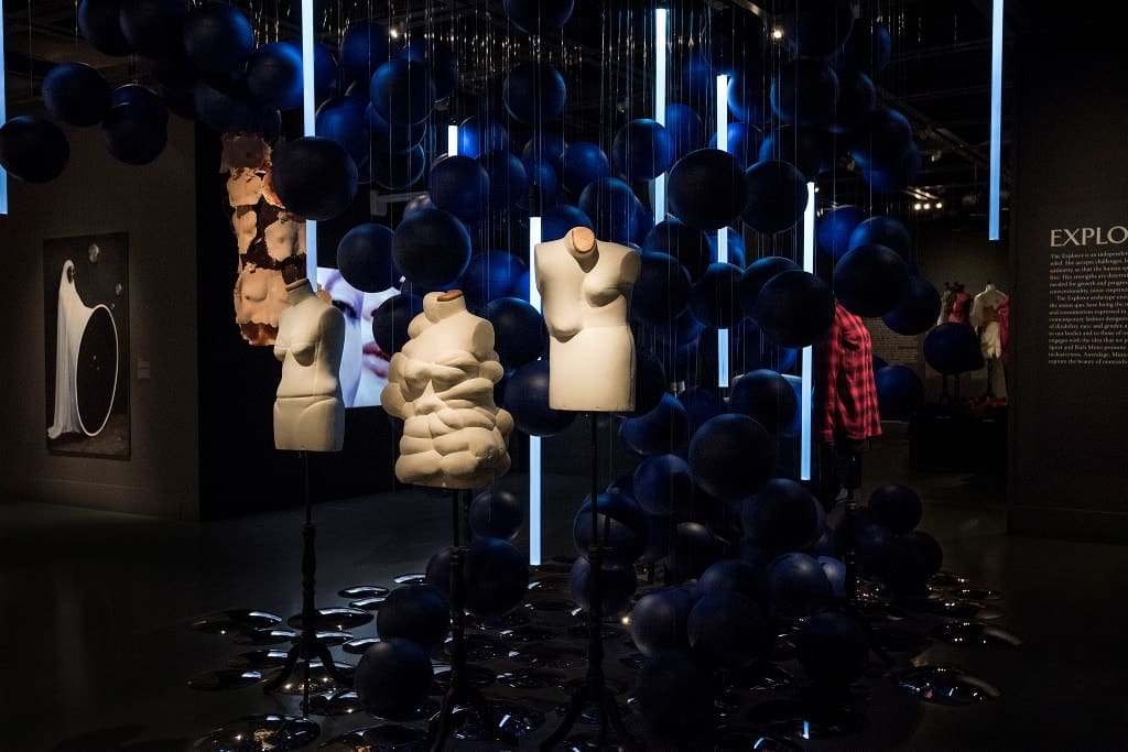 a group of mannequins in a room with blue balls